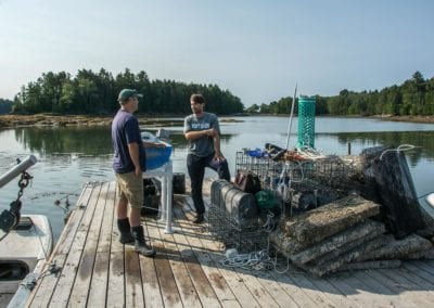 Peter and John talking on raft of Dingley Cove Oysters on New Meadows River in Maine